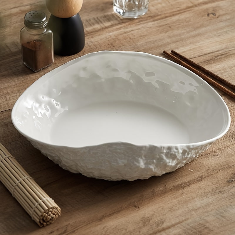 Shell-shaped ceramic dish with a textured exterior.