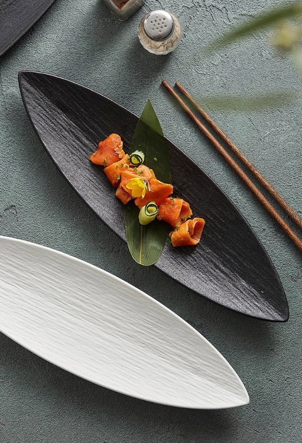 Leaf-inspired matte black ceramic plate with food.