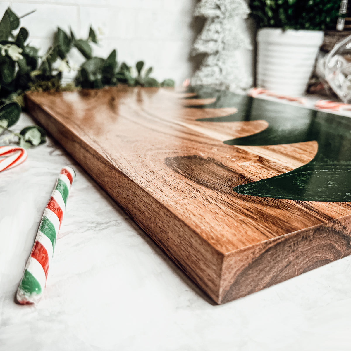 Handmade wooden serving board with a green resin Christmas tree inlay.