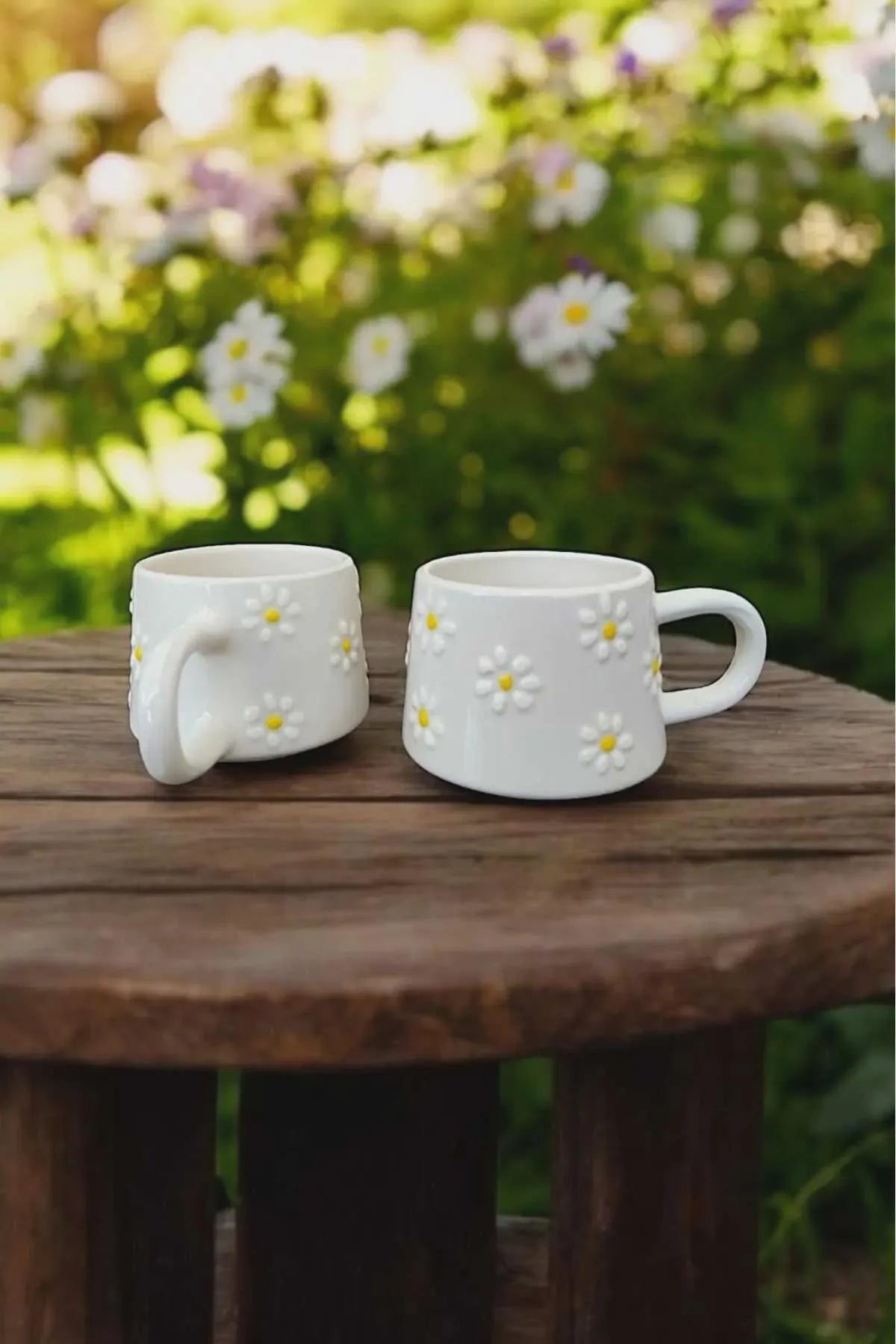 Handmade ceramic mug set with hand-painted yellow daisies.