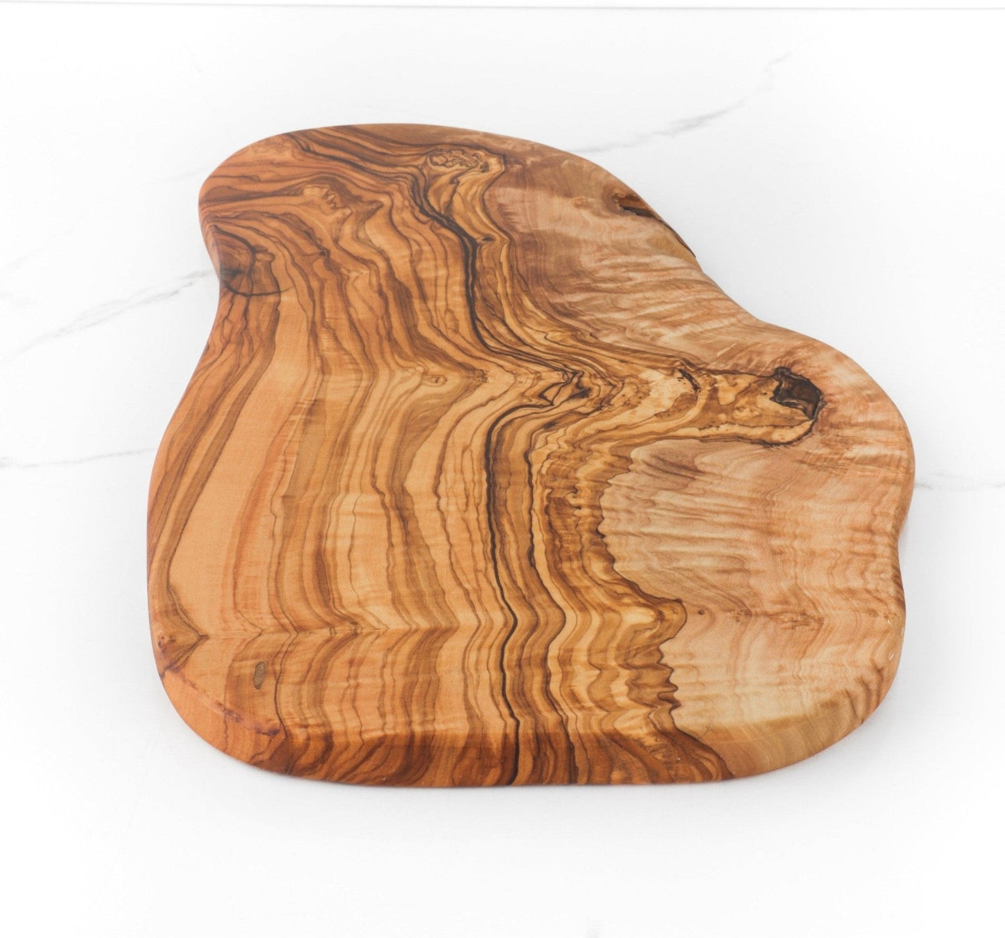 Handcrafted olive wood cutting board with natural edges and rich grain.