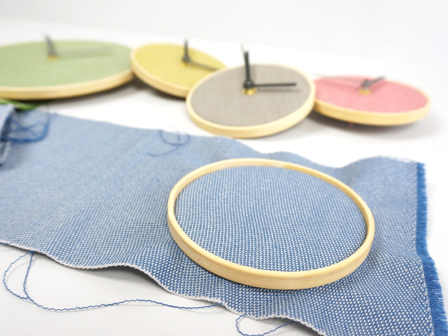 Upholstery off-cut fabric clock with a wooden hoop and blue fabric.