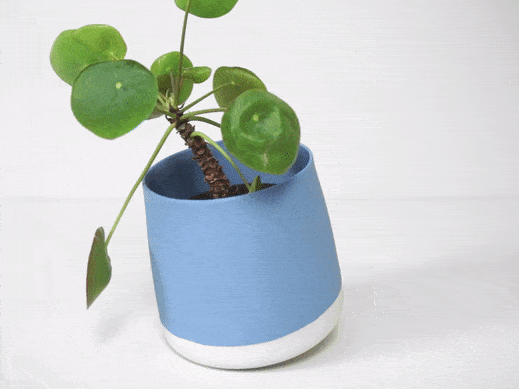 Indoor tilting flower pot in blue with green leaves, showcasing modern design and dynamic movement.