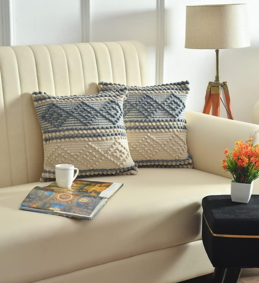 Beige sofa with patterned cushions, a cup, and a magazine in a living room setting.