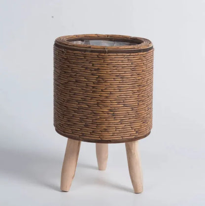 Wicker plant stand with wooden legs on a white background
