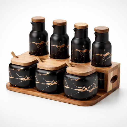 Set of black marbled jars with wooden lids on a wooden tray against a white background