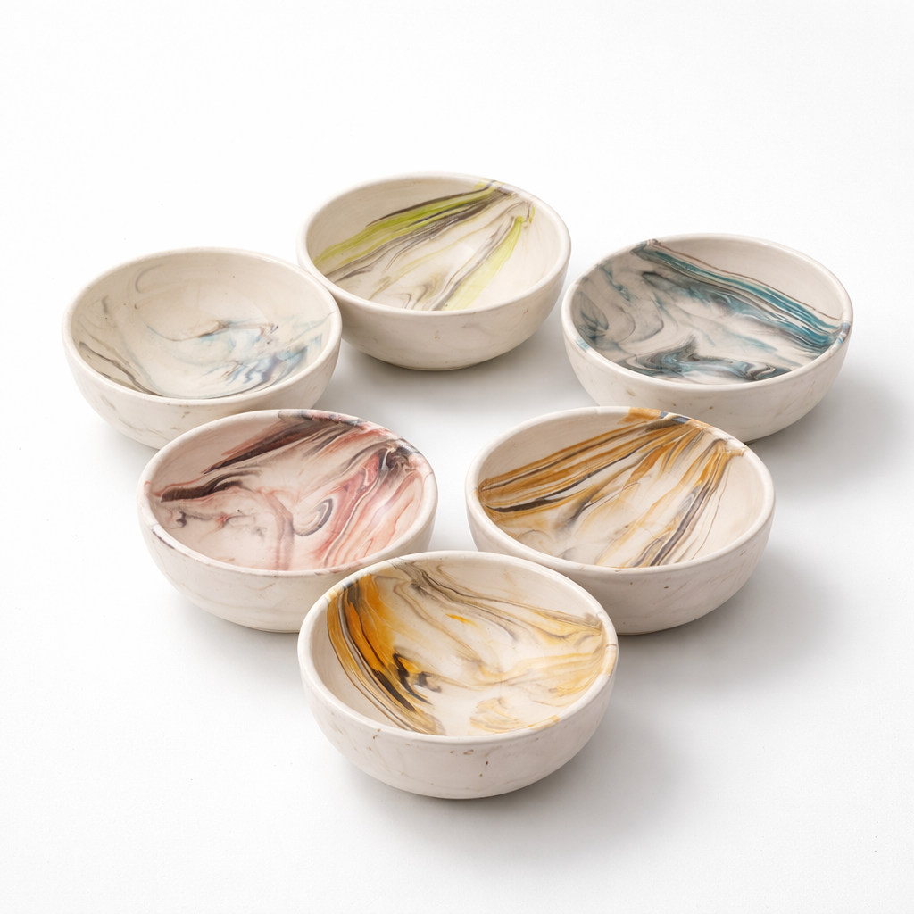 Set of six ceramic bowls with marbled patterns on a white background
