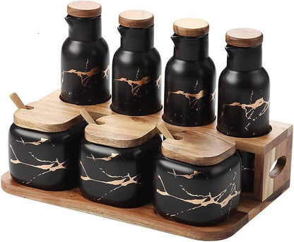 Set of black ceramic containers with wooden lids on a wooden tray