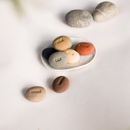 Set of stones with engraved text on a white plate and surface