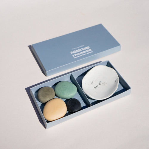 Set of stones and a small dish in an open box on a light gray background