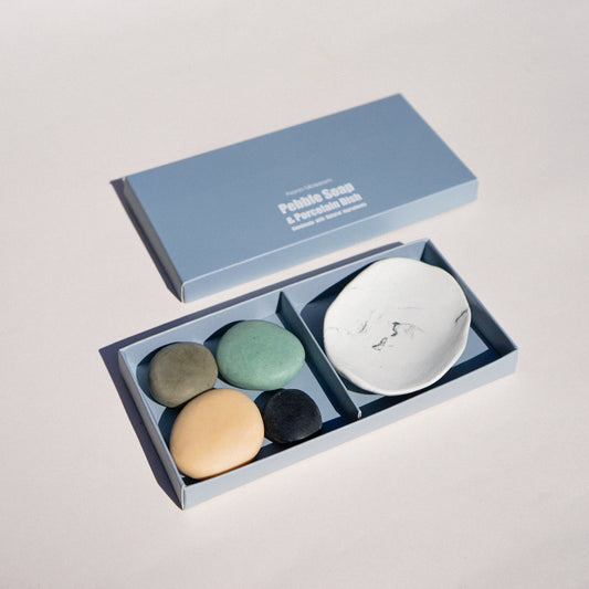 Set of stones and a small dish in an open box on a light gray background