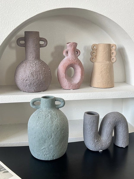 Set of five ceramic vases on a shelf with a black surface in front