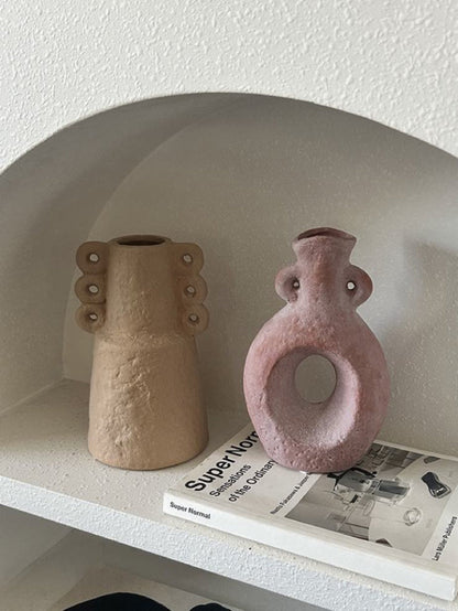Two ceramic vases on a shelf with a magazine underneath.
